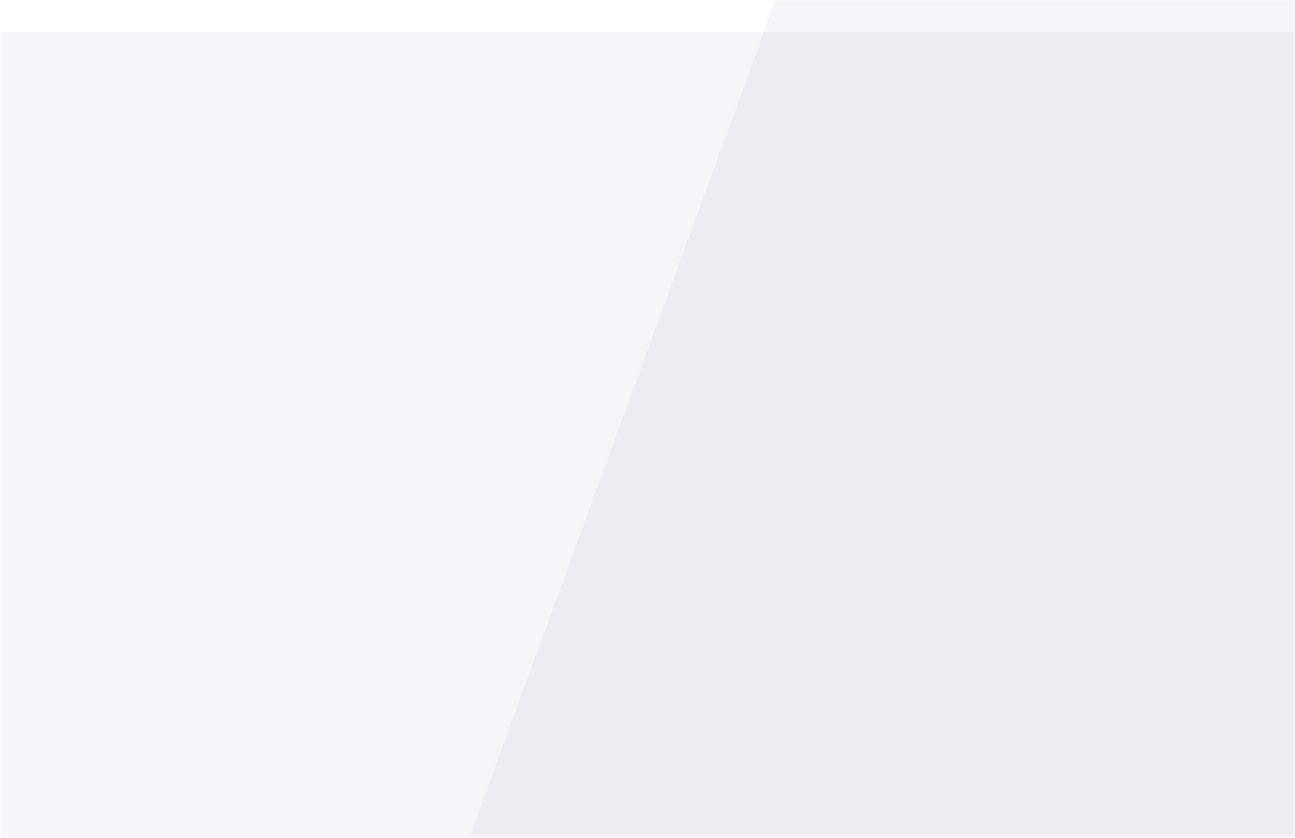 A modern, minimalist living room with a large gray sectional sofa adorned with various cushions. In front of the sofa is a round coffee table with a black metal frame and a wooden top, holding a small plant and decorative items. The room features a light wood floor and a large window with sheer white curtains, allowing natural light to fill the space. A tall green plant is placed near the window, adding a touch of nature to the room. The overall color palette is neutral with shades of gray, white, and natural wood tones.